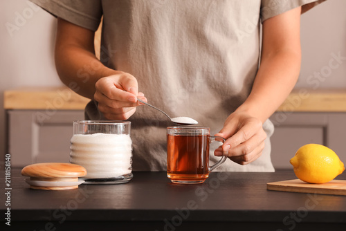 Person adding sugar to a cu...