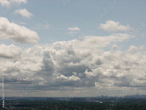 Cuadro en lienzo Aerial drone view of distant city skyline beyond a wooded suburban landscape in