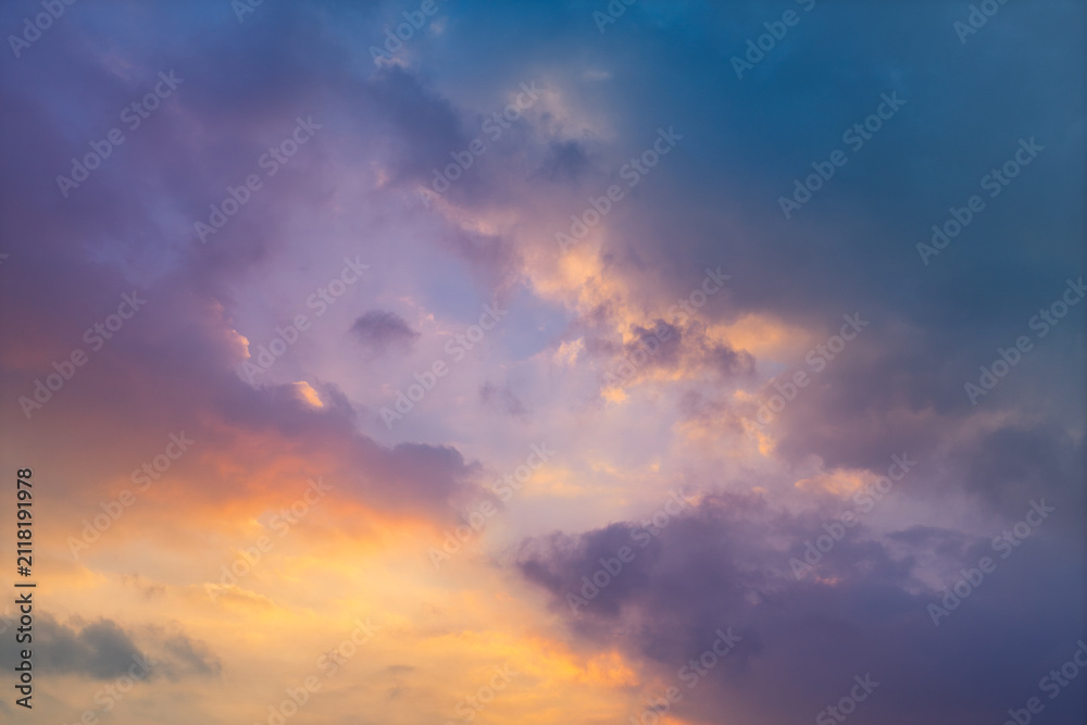 Obraz premium Clouds illuminated by a colorful sunset with golden, pink and blue tones. Natural background for weather, landscape, design and atmospheric concepts.