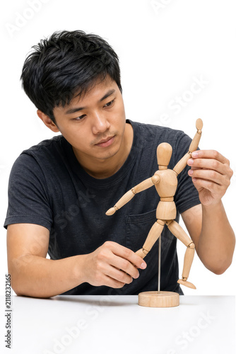 Creative Young Asian Artist Posing Wooden Mannequin for Drawing Reference Isolated