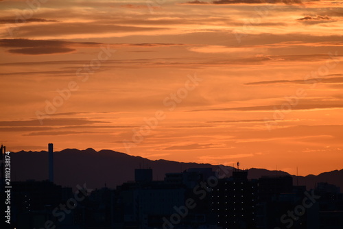 遠くに山のシルエットが浮かぶ夕暮れの風景