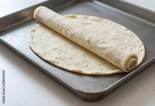 Unrolled pizza dough on a m...