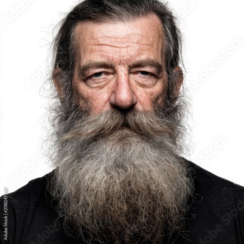Weathered Wisdom: A close-up portrait of an elderly man with a long, gray beard and intense gaze, conveying a sense of history and experience.