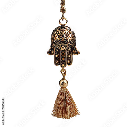 Ornate gold-toned hand pendant with intricate designs and a flowing tassel, suspended against a black background