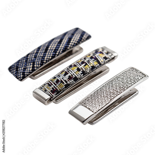 Three stylish tie clips with patterned tops and metallic clasps, arranged diagonally on a black backdrop