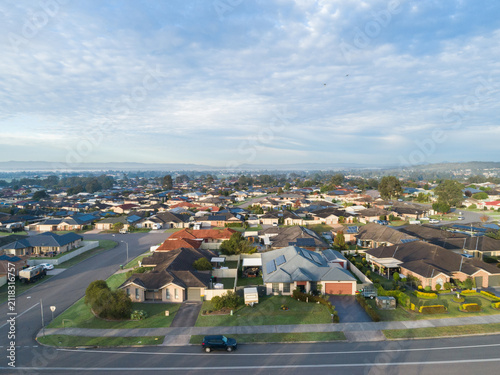 Aerial townscape of residential suburb in country town in Australia on morning with misty horizon