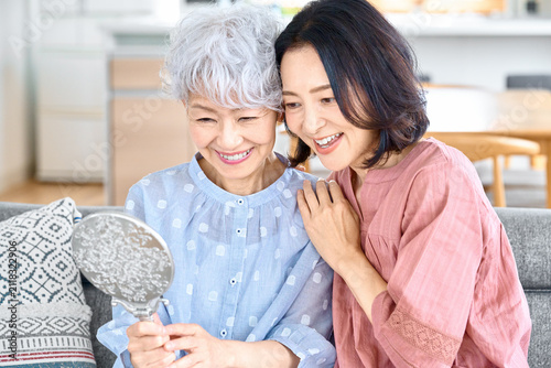 鏡を見て微笑む高齢女性と娘の親子