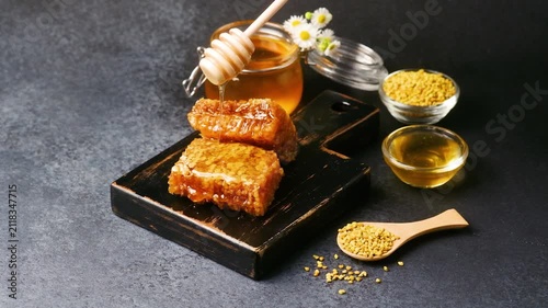Honeycomb and bee pollen presented on a dark background