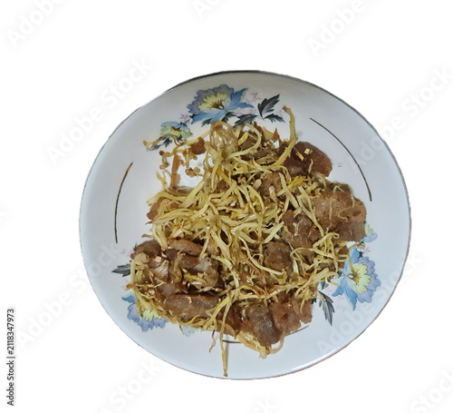 Isolated stir-fried pork with shredded ginger in a floral patterned ceramic plate on a white background for Asian food concepts.