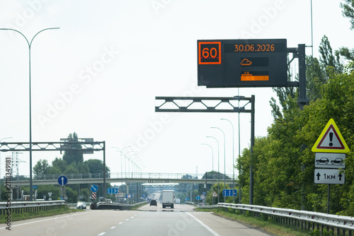 Картината върху платно Modern motorway with overhead electronic board showing speed advice and travel a