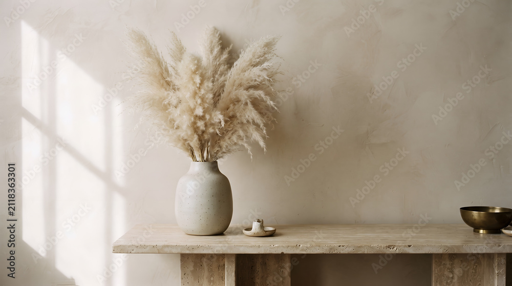 Obraz premium A single ceramic vase with dried pampas grass resting on a beige table against a textured limewash plaster wall, soft window shadow, modern minimalist background
