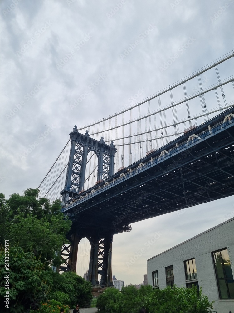 Fototapeta premium Low angle view of the Manhattan Bridge against a cloudy sky in New York City.