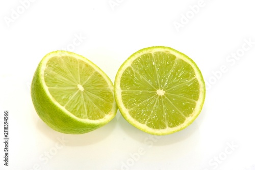 Two fresh green lime halves isolated on pure white background closeup