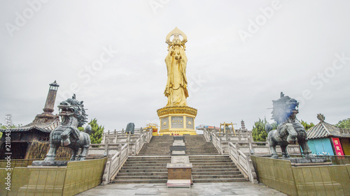 Fotografie Golden Buddha Statue at Sacred Mountain Temple with Stone Stairs