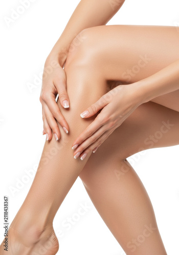 Detailed macro of toned caucasian woman's legs and hands with french manicure gently caressing immaculate, radiant skin in a high-key studio, against transparent. Concept of ultimate self-care and