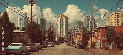 Urban Vista - A Street View of City Buildings Under Cloudy Skies.