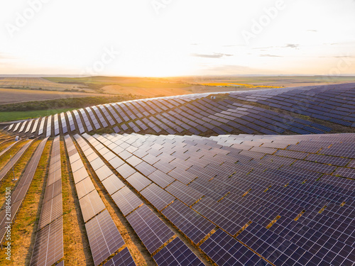 Sunrise over solar panels in a large field during the morning