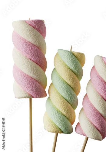 three hyperdetailed artisanal gourmet marshmallows on skewers (pink striped, yellow/green swirled) displaying powdery, fluffy texture in a macro 3/4 view against a transparent studio background.