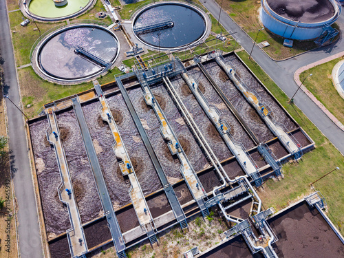 Water treatment facility processes water and waste using various large tanks and pipes in a designated industrial area during daytime