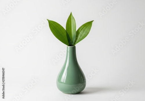 Minimalist Green Ceramic Vase with Three Fresh Green Leaves on White Background for Modern Interior Decor
