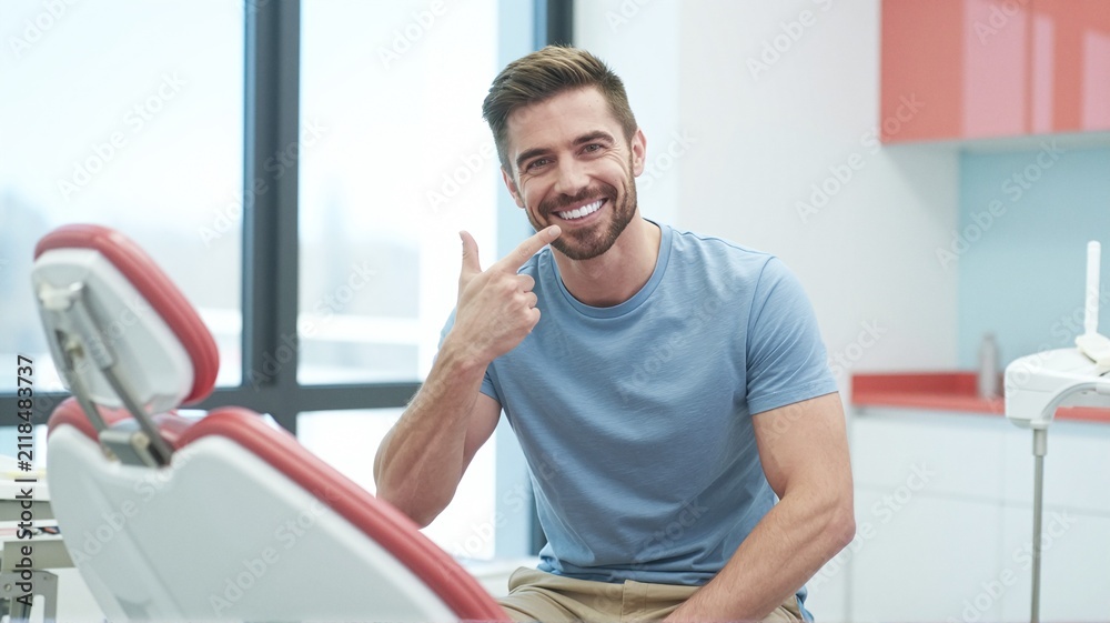 Fototapeta premium Man proudly shows off his healthy white teeth after a dental visit