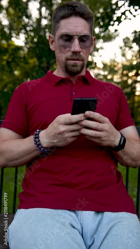 Man of Caucasian human using mobile phone while on street.