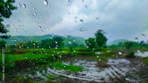 rain drops on a glass of the window of the car in the rainy season.