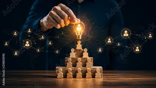 Innovative leadership concept with hand placing glowing lightbulb figure on top of business team pyramid