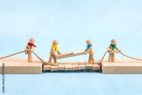 Wooden Figures Building a Bridge Together