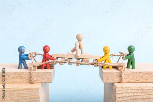 Wooden Figures Building a Bridge Together