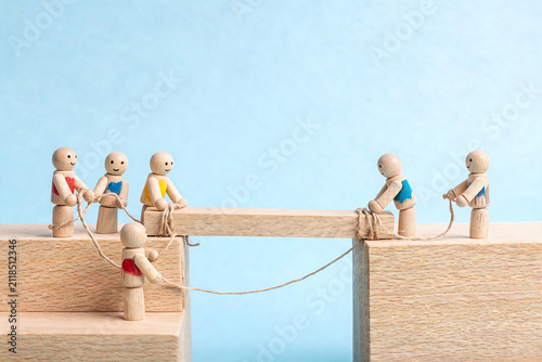 Wooden Figures Building a Bridge Together