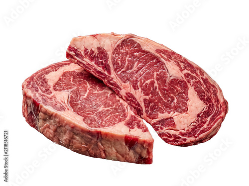 Two premium raw ribeye beef steaks, richly marbled for superior flavor and tenderness, isolated on transparent.