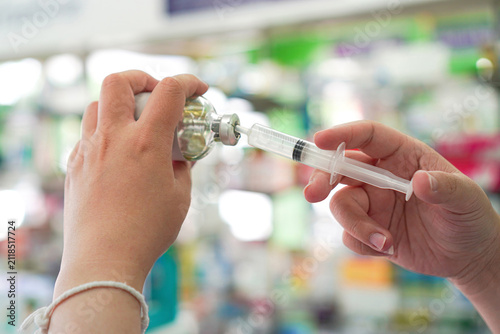 Obraz na płótnie Pharmacist Demonstrating Medication Withdrawal from Glass Vial with Syringe at C