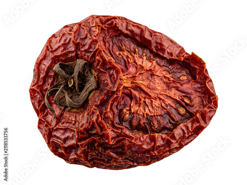 Close-up of a whole, richly textured sun-dried tomato with stem on a transparent background.