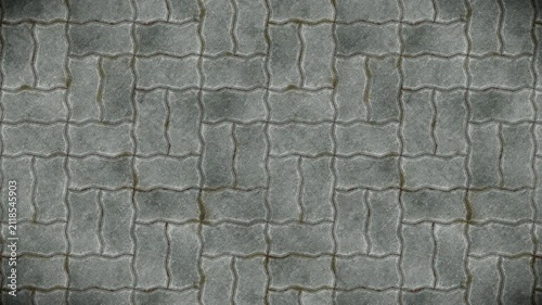 Weathered grey interlocking paving stones pattern offers a seamless loop background.