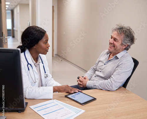 Doctor, physician or medical specialist sharing positive examination, laboratory test, diagnosis or treatment results with patient, couple or family during healthcare consultation, giving good news