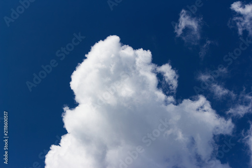 Foto Huge fluffy white cumulus cloud floating against a vivid deep blue sky, catching