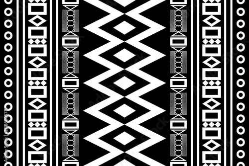 Bold black and white tribal geometric seamless pattern featuring diamond, square, circle and vertical stripe motifs for textile, apparel, fabric prints and surface design.