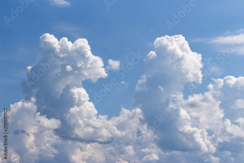 Fotografie Massive towering white cumulus clouds drift across a vibrant azure sky creating