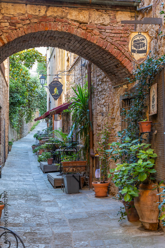 Принти на полотні Old town street with archway and charming restaurant in Massa Marittima