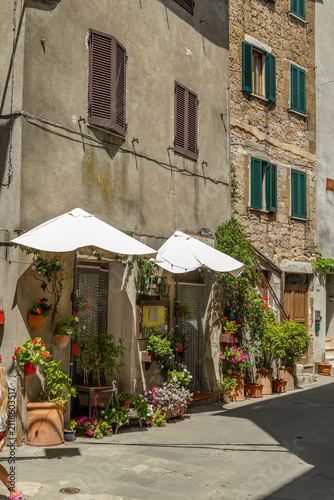 Konstfotografi Pitigliano street with charming flowers and rustic architecture