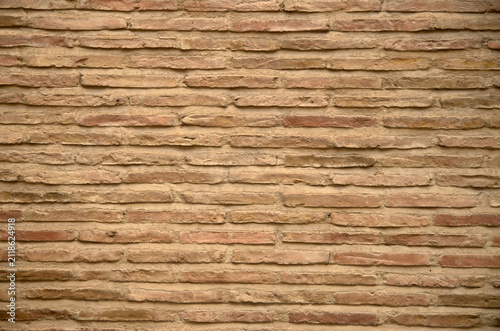 Background texture of old traditional thin yellow brick wall in Andalusia, Spain