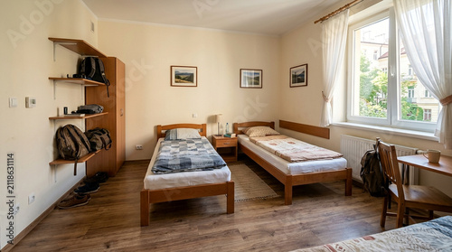 Cozy Hostel Room with Twin Beds, Backpacks, and Natural Light