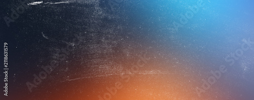 Abstract textured background with a gradient from dark blue to bright orange creating a vibrant and dynamic visual effect with grainy overlay.