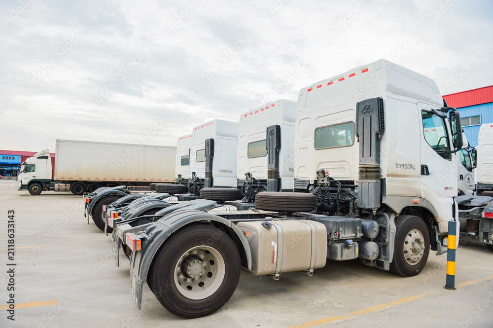 Obraz premium White semi truck fleet parked at logistics yard
