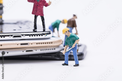 Canvastavla Miniature workers repairing stacked smartphones on white background