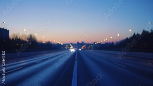 Blurred highway at dusk with light trails and bokeh headlights, urban road perspective with motion blur