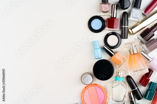 Fotografía Colorful makeup products spread on white surface.
