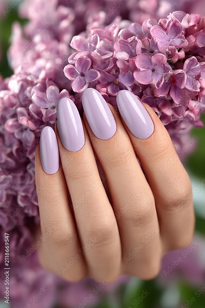 Fototapeta premium Woman Hand with Beautiful Pastel Lilac Manicure Holding Fresh Blooming Spring Lilac Flower Scents