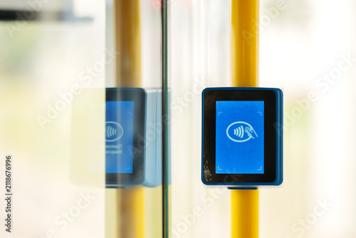 Contactless ticket validator terminal inside public transport. Electronic payment machine for credit cards and travel passes on city bus, train, or tram.